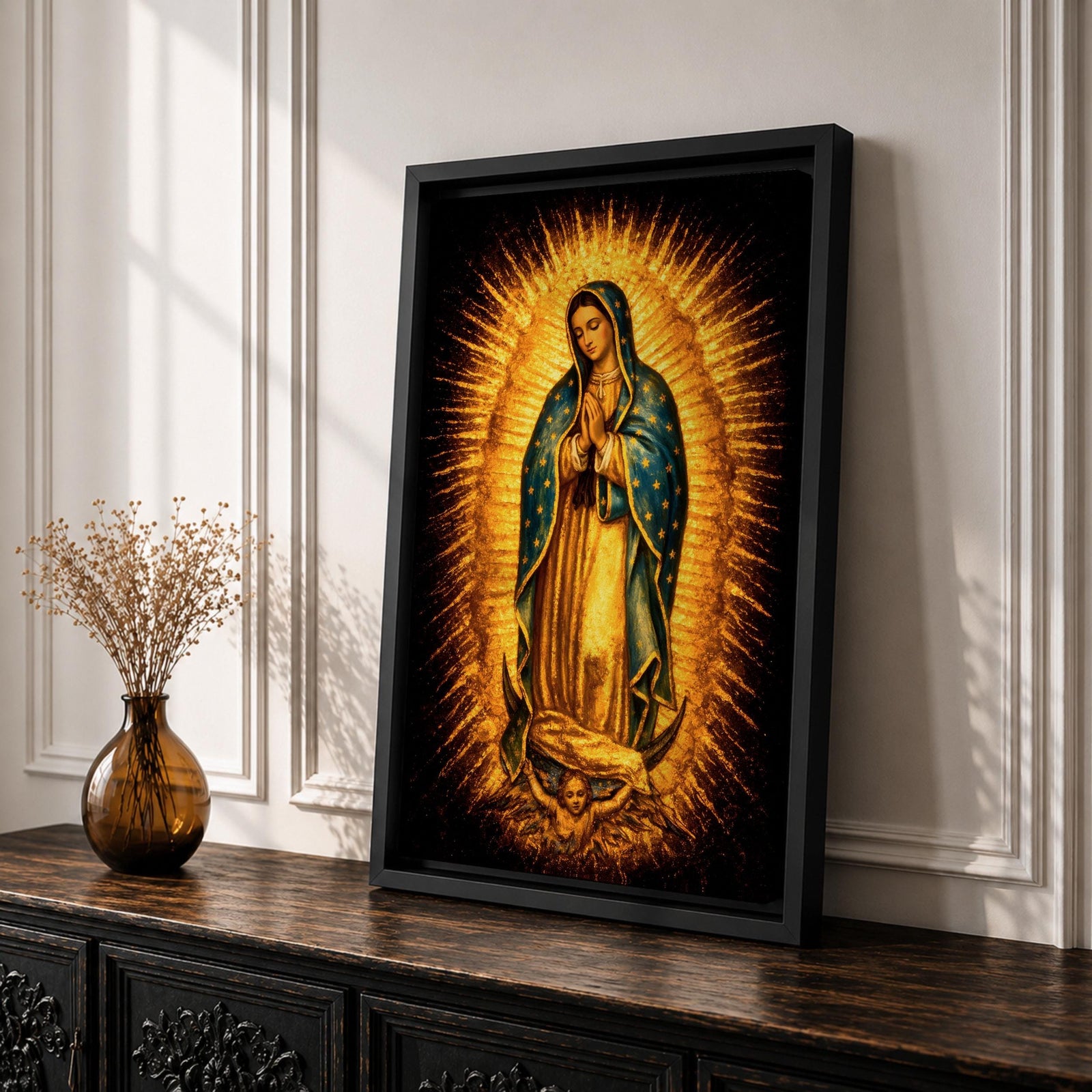 Traditional Our Lady of Guadalupe Catholic icon showing the Virgin Mary standing in prayer with hands clasped, surrounded by radiant sunburst rays. She wears a star covered mantle and flowing robe while standing on a crescent moon supported by an angel below, presented in a classic devotional religious composition associated with Mexican Catholic imagery.