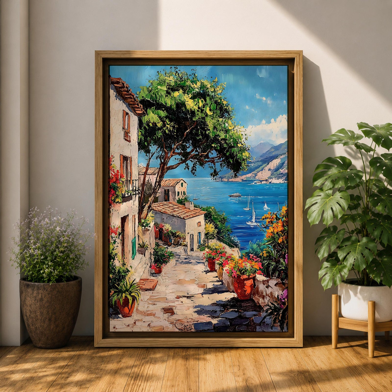This artwork depicts a vibrant Italian village scene with terracotta-roofed houses, lush greenery, and colorful flowers lining a stone pathway that leads down to a bright blue Mediterranean sea with sailboats and distant mountains, rendered in a realistic style capturing coastal charm.
