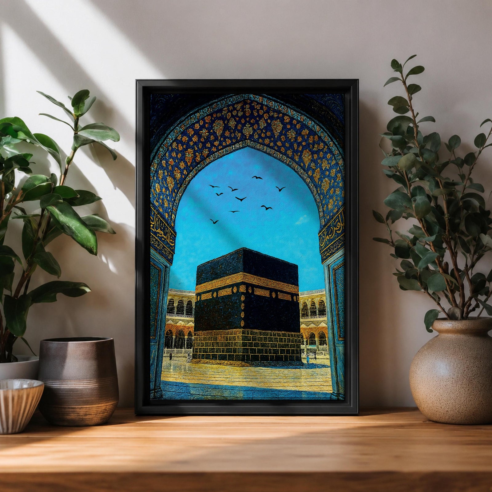 Artwork of the Kaaba in Masjid Haram framed by an ornate Moorish arabesque archway with intricate blue and gold patterns and birds flying across a bright sky above the mosque courtyard.