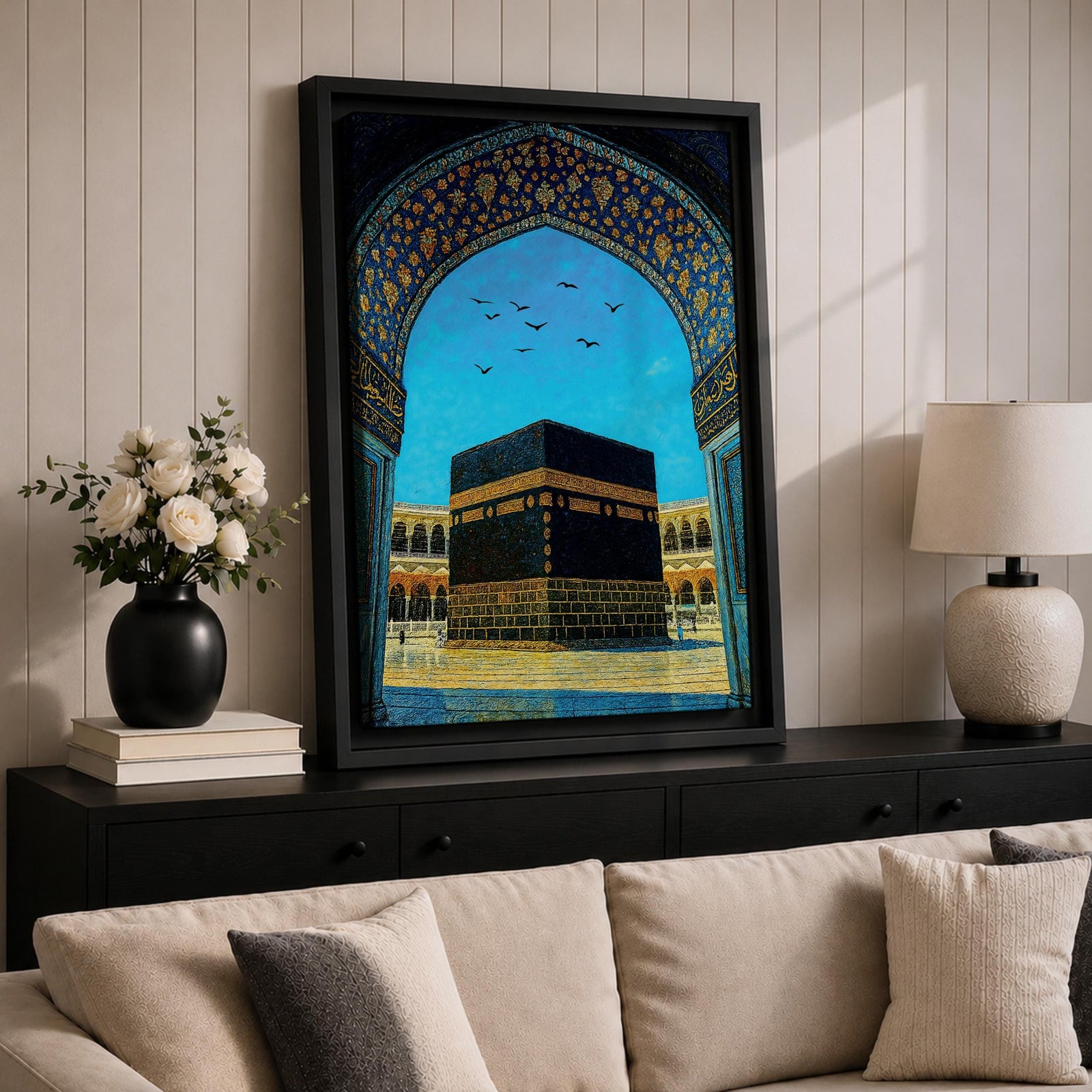 Artwork of the Kaaba in Masjid Haram framed by an ornate Moorish arabesque archway with intricate blue and gold patterns and birds flying across a bright sky above the mosque courtyard.