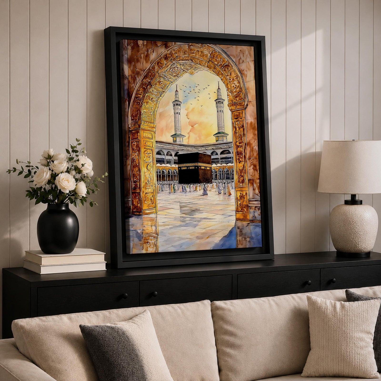 Watercolor artwork of the Kaaba in Masjid Haram viewed through an ornate mosque archway with twin minarets rising above the courtyard and pilgrims gathered around the sacred sanctuary.