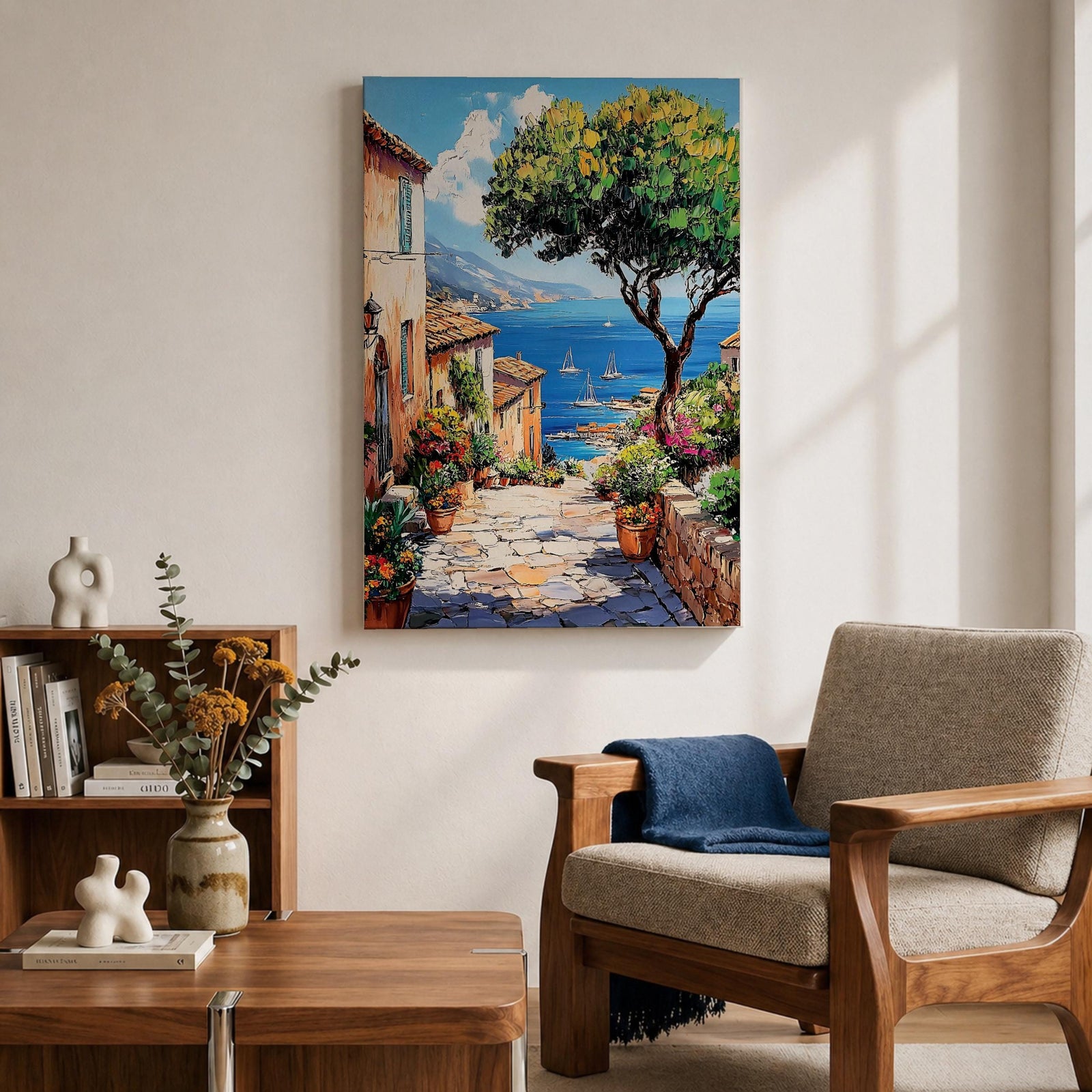 A vibrant framed canvas painting depicting a charming coastal village with stone-paved streets, terracotta rooftops, lush greenery, colorful flowers, and sailboats on a deep blue sea under a clear sky, rendered in a detailed, realistic style capturing Mediterranean summer ambiance.