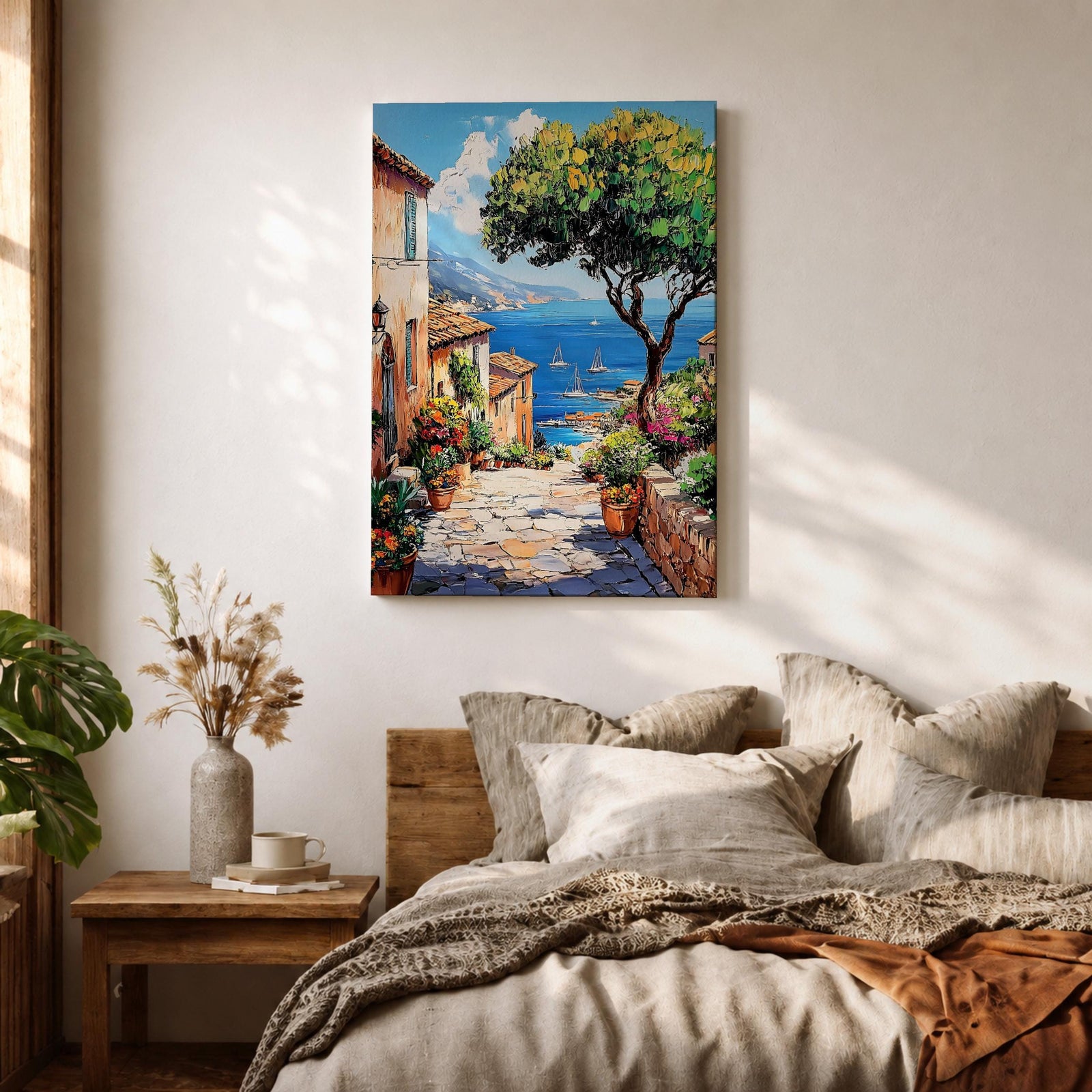 A vibrant framed canvas painting depicting a charming coastal village with stone-paved streets, terracotta rooftops, lush greenery, colorful flowers, and sailboats on a deep blue sea under a clear sky, rendered in a detailed, realistic style capturing Mediterranean summer ambiance.
