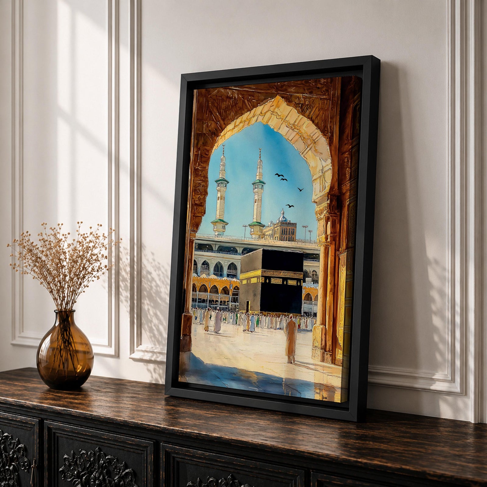 Watercolor style artwork showing the Kaaba at Masjid Al Haram in Mecca framed through a large golden mosque arch, with pilgrims gathered around the courtyard and two tall minarets rising against a clear blue sky.