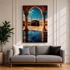 Framed wall art showing the Kaaba at Masjid Al Haram in Mecca viewed through a grand marble archway with columns and reflective courtyard tiles under a bright blue sky.