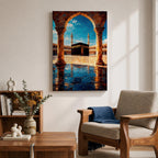 Framed wall art showing the Kaaba at Masjid Al Haram in Mecca viewed through a grand marble archway with columns and reflective courtyard tiles under a bright blue sky.