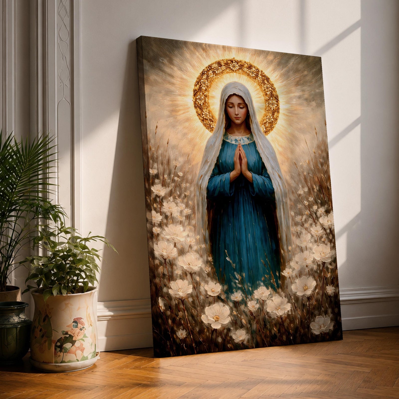 Painting of the Virgin Mary standing in prayer with hands clasped and head bowed, wearing a flowing blue robe and white veil, surrounded by a radiant golden halo and soft glowing light while standing within a field of delicate white wildflowers in a devotional Marian composition.