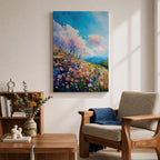 A vibrant impasto painting of a wildflower meadow featuring dense clusters of colorful flowers under a bright blue sky with fluffy clouds. The textured brushstrokes create depth and movement, capturing a lively natural landscape scene with rolling hills in the distance.