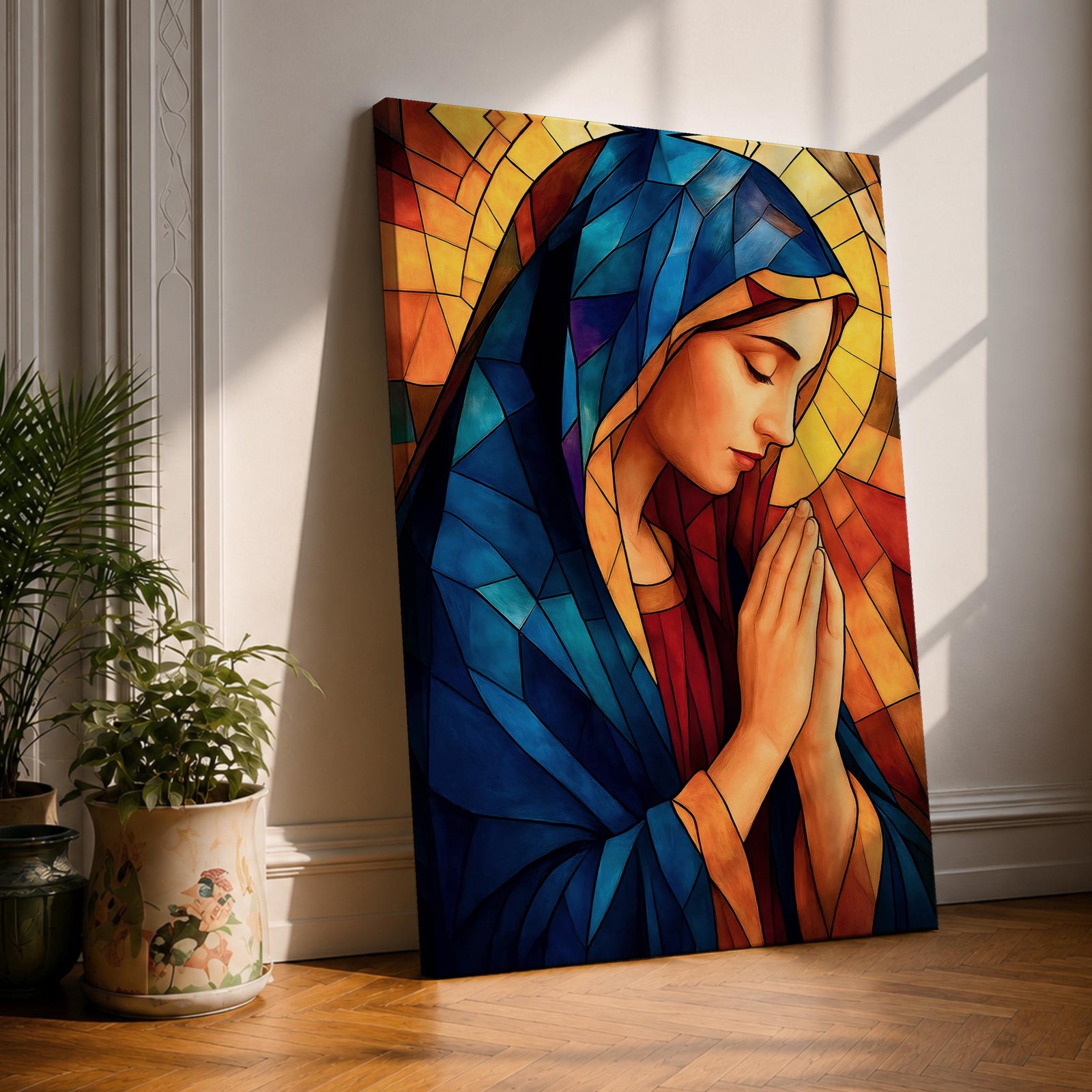 Stained glass style painting of the Virgin Mary shown in profile with head bowed and hands clasped in prayer, wearing a blue mantle and red garment, surrounded by geometric stained glass panels forming a radiant halo like background in a devotional Catholic Marian composition.
