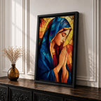 Stained glass style painting of the Virgin Mary shown in profile with head bowed and hands clasped in prayer, wearing a blue mantle and red garment, surrounded by geometric stained glass panels forming a radiant halo like background in a devotional Catholic Marian composition.
