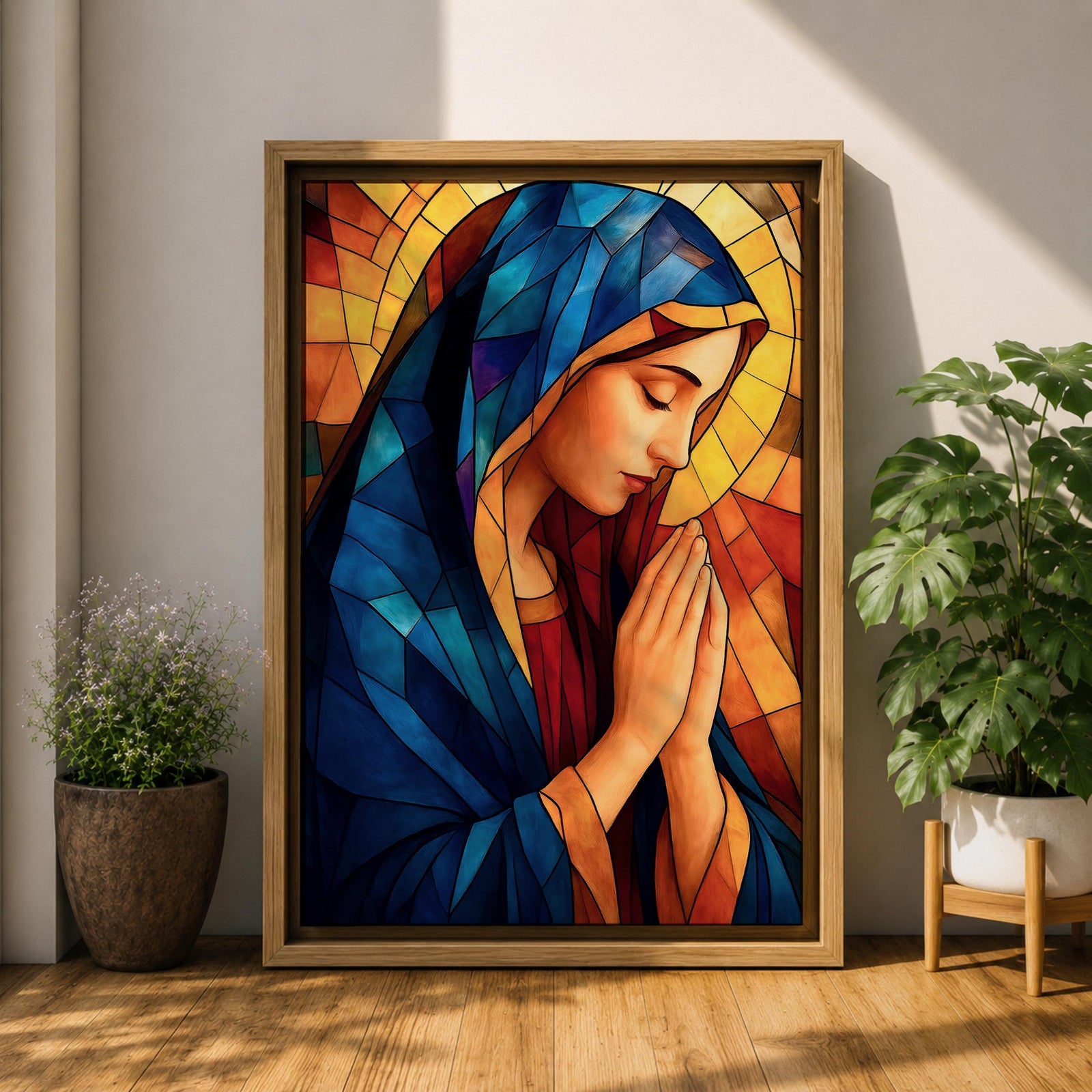 Stained glass style painting of the Virgin Mary shown in profile with head bowed and hands clasped in prayer, wearing a blue mantle and red garment, surrounded by geometric stained glass panels forming a radiant halo like background in a devotional Catholic Marian composition.