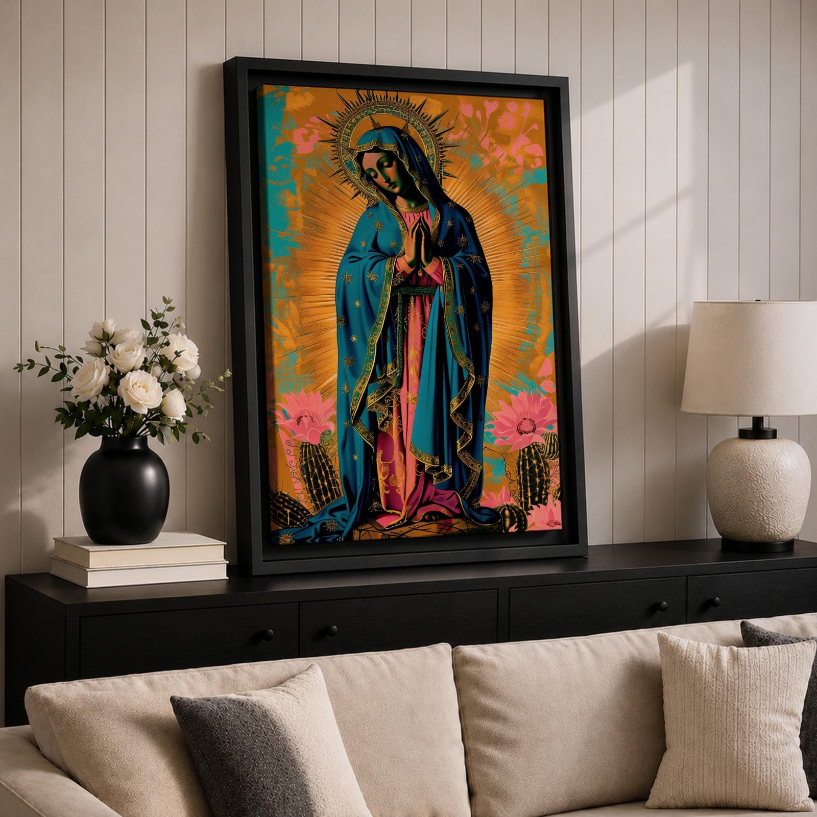 Artwork of Our Lady of Guadalupe standing in prayer with hands clasped and head bowed, wearing a star covered blue mantle and rose colored gown, surrounded by radiant golden rays with stylized flowers near the base, rendered in a vibrant devotional Marian composition inspired by traditional Guadalupe imagery.