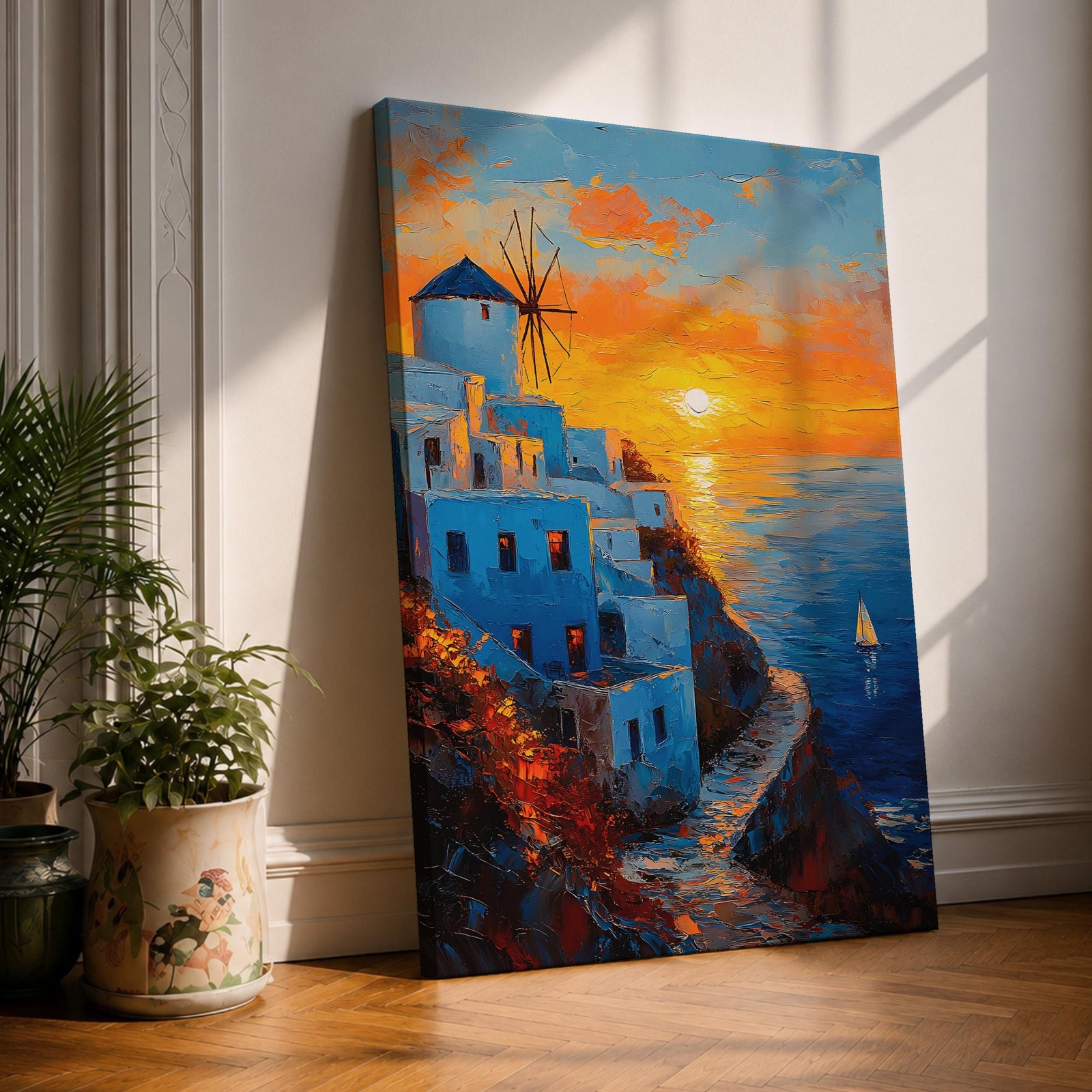 An impasto style framed canvas painting depicting a Santorini sunset over whitewashed buildings with a windmill on a cliffside overlooking the sea. The vibrant sunset sky reflects on the water with a small sailboat visible, capturing a Mediterranean coastal landscape scene with textured brushstrokes.