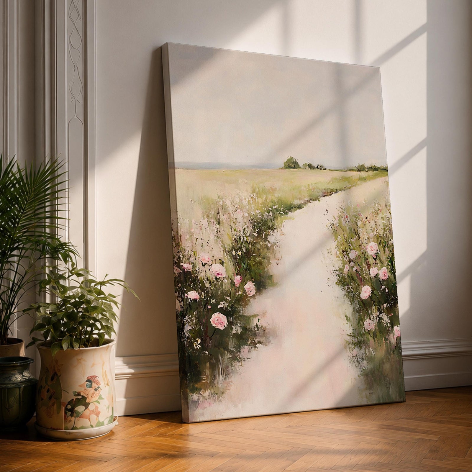 A vintage style framed canvas painting depicting a floral pathway bordered by blooming pink roses and greenery leading into a soft, open landscape. The artwork features impressionistic brush strokes with a romantic cottagecore aesthetic, emphasizing natural beauty and rustic charm in a serene outdoor setting.