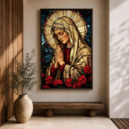 Stained glass style artwork of the Virgin Mary with head bowed and hands clasped in prayer, wearing a cream veil and red garment, surrounded by a radiant circular halo and red roses at the base, rendered with detailed stained glass panels and rich colors in a devotional Marian composition.