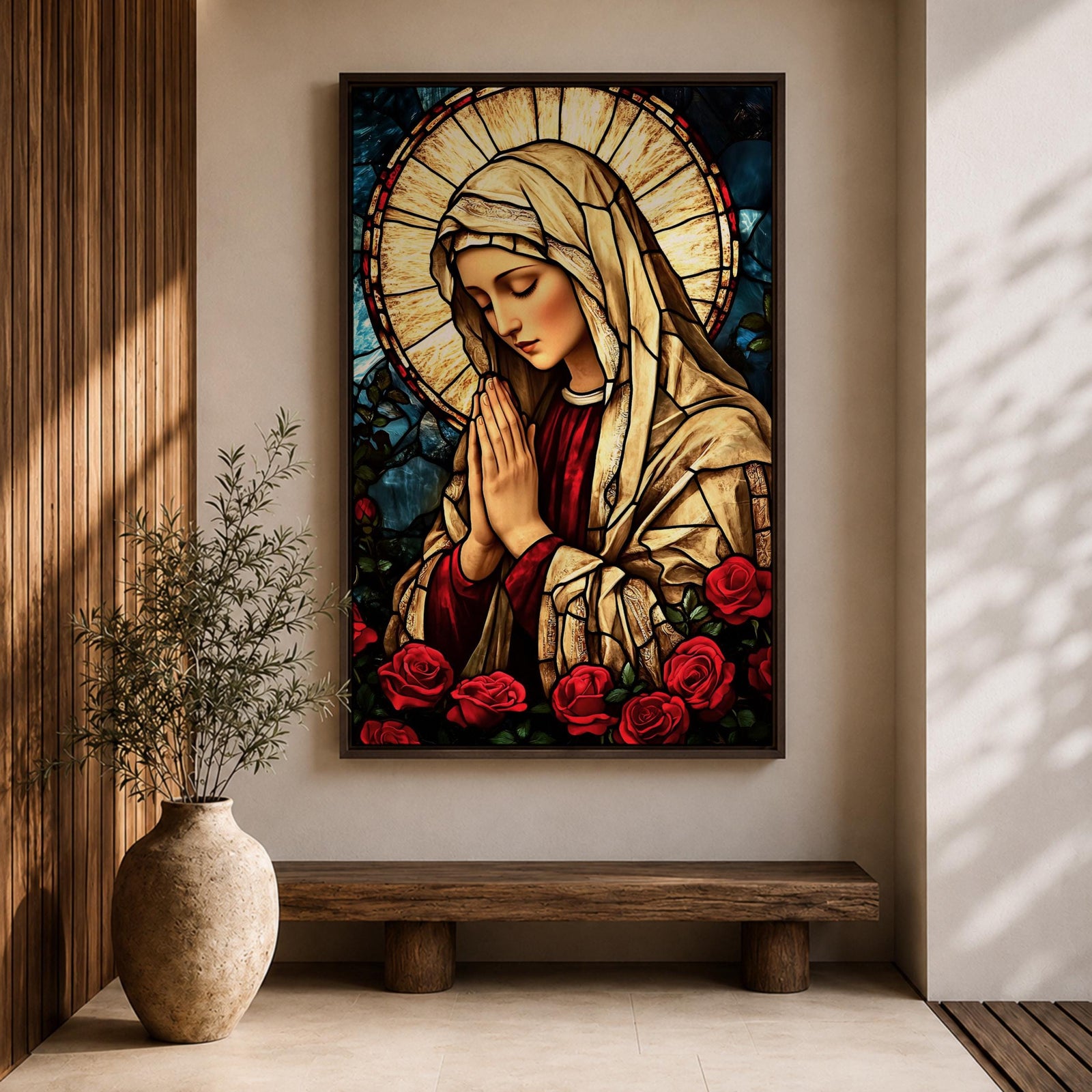 Stained glass style artwork of the Virgin Mary with head bowed and hands clasped in prayer, wearing a cream veil and red garment, surrounded by a radiant circular halo and red roses at the base, rendered with detailed stained glass panels and rich colors in a devotional Marian composition.