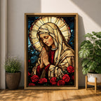 Stained glass style artwork of the Virgin Mary with head bowed and hands clasped in prayer, wearing a cream veil and red garment, surrounded by a radiant circular halo and red roses at the base, rendered with detailed stained glass panels and rich colors in a devotional Marian composition.