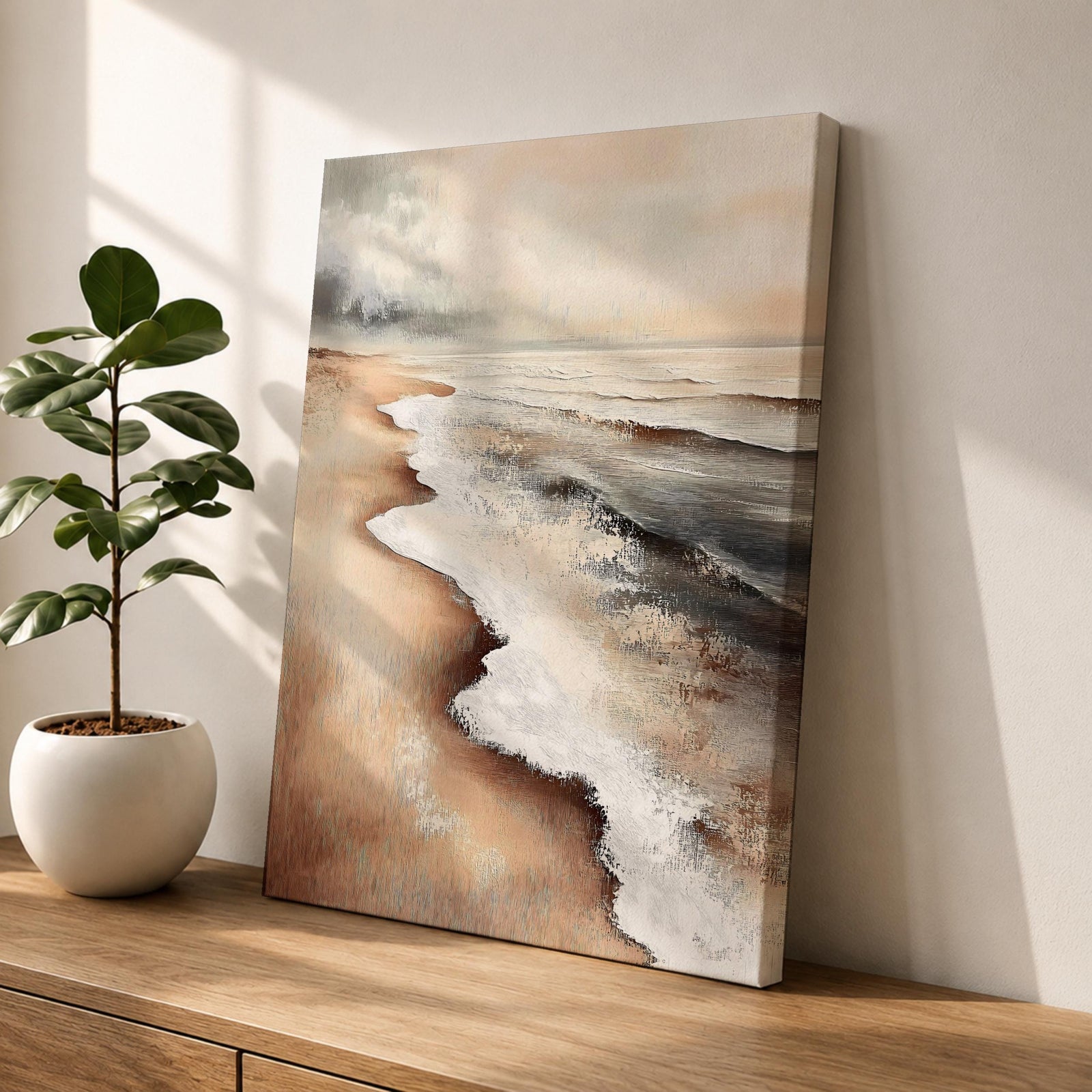 A framed canvas painting of a coastal seascape depicting waves gently washing onto a sandy beach under a cloudy sky. The artwork captures the natural landscape with realistic textures and muted tones, emphasizing the ocean shore and shoreline details in a classic style.