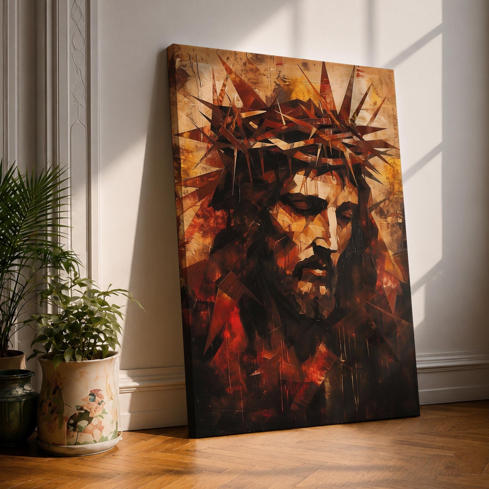 Geometric style portrait of Jesus Christ wearing a crown of thorns, rendered with angular fragmented shapes forming his solemn face and downward gaze. Warm tones of amber, red, and deep brown surround the figure, while sharp triangular forms emphasize the crown, creating a dramatic sacred portrait composition.