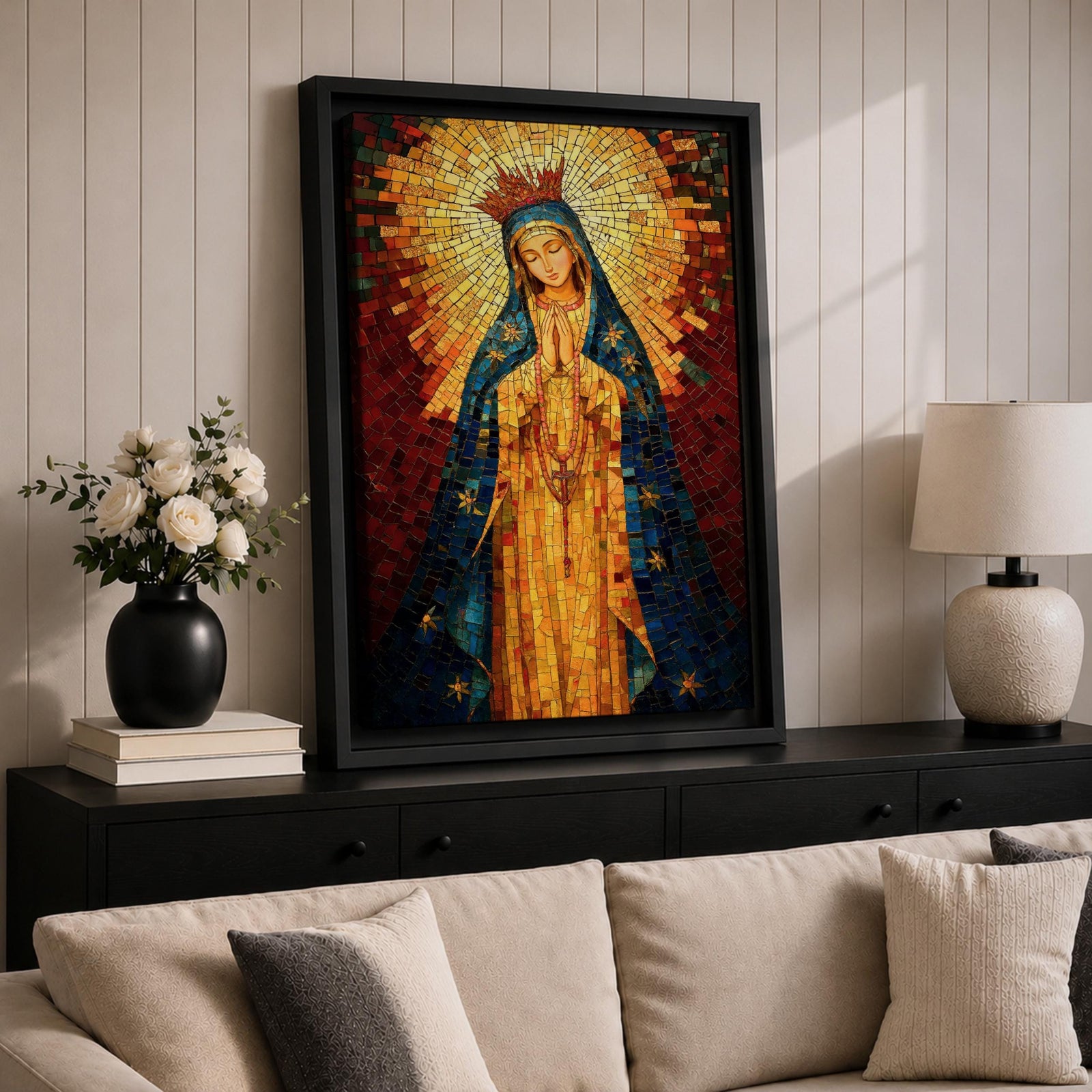 A mosaic-style icon of Virgin Mary depicts the Blessed Mother with hands clasped in prayer, wearing a blue mantle adorned with stars and a radiant golden halo behind her head, composed of small colorful tiles forming a vibrant religious portrait.