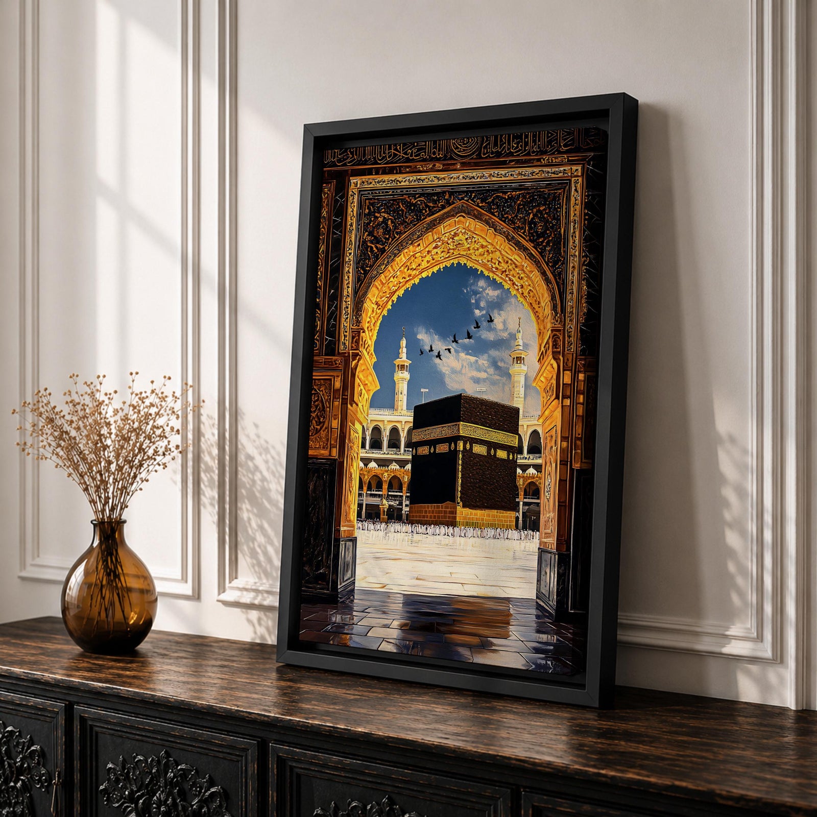 Artwork depicting the Kaaba in Masjid Al Haram in Mecca viewed through an ornate golden mosque arch, with two tall minarets rising behind the sacred courtyard and birds flying across a bright blue sky.