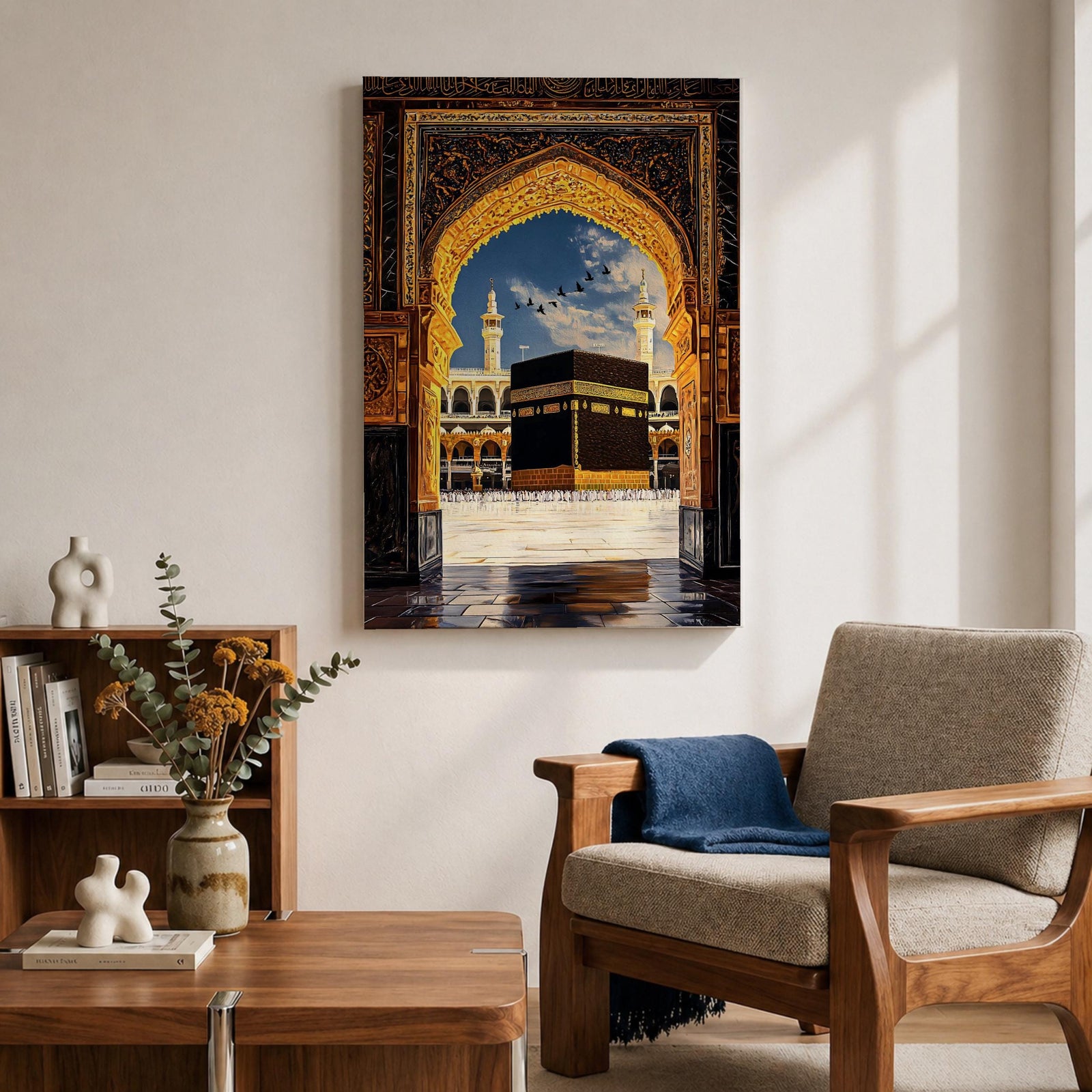 Artwork depicting the Kaaba in Masjid Al Haram in Mecca viewed through an ornate golden mosque arch, with two tall minarets rising behind the sacred courtyard and birds flying across a bright blue sky.