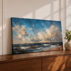 A panoramic seascape painting showing rolling ocean waves moving toward a sandy shoreline beneath a wide sky filled with soft clouds and warm light. The composition stretches across the horizon with textured brushstrokes capturing movement in the water and subtle reflections of blue, white and golden tones across the sea.