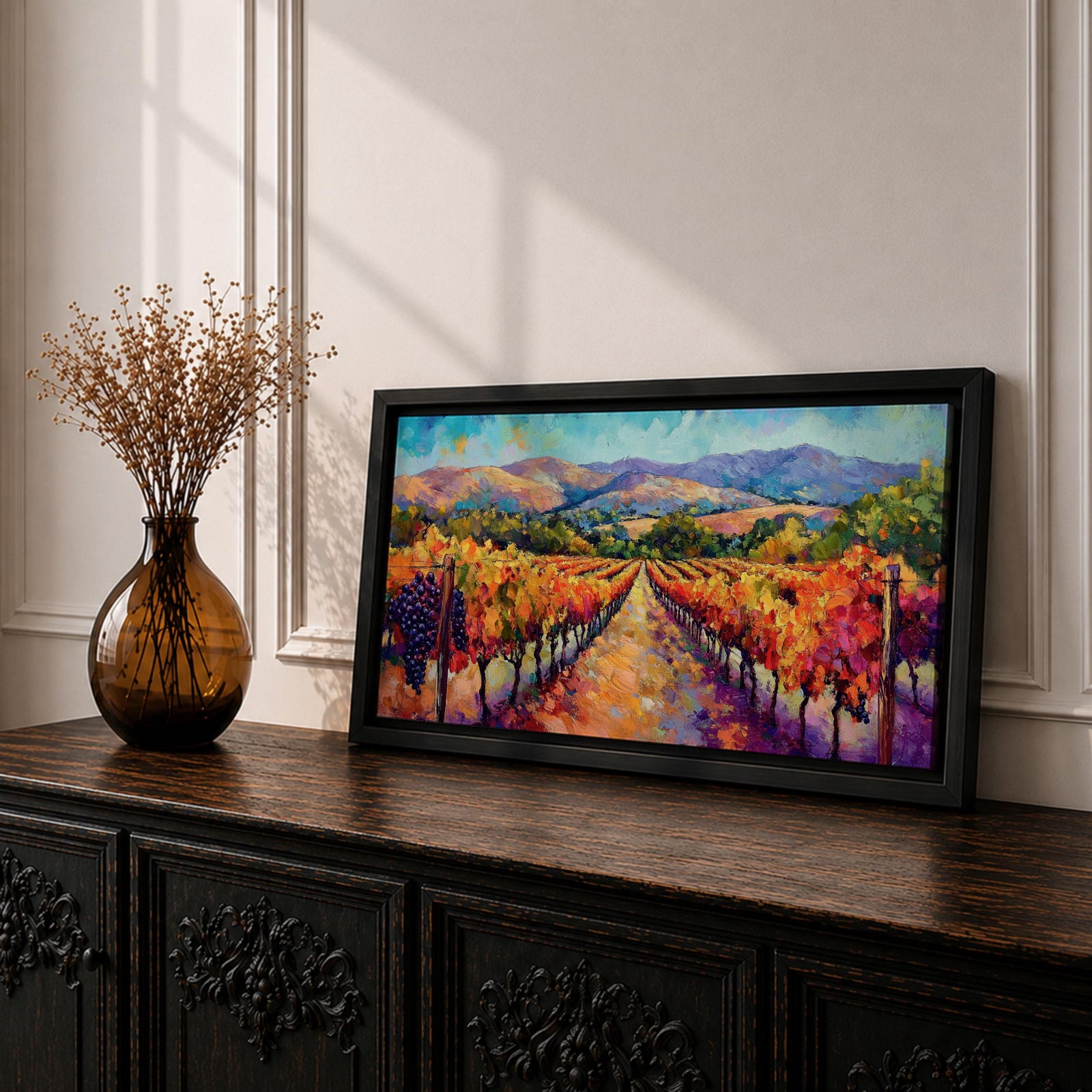 A panoramic vineyard landscape painting showing long rows of grapevines covered in red and golden autumn leaves stretching toward distant mountains beneath a bright sky. Purple grape clusters hang beside the vines while a central path leads through the field, capturing a colorful wine country valley with bold impressionist brushstrokes.