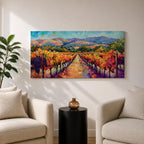 A panoramic vineyard landscape painting showing long rows of grapevines covered in red and golden autumn leaves stretching toward distant mountains beneath a bright sky. Purple grape clusters hang beside the vines while a central path leads through the field, capturing a colorful wine country valley with bold impressionist brushstrokes.