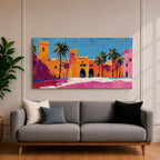 Panoramic painting of a Moroccan kasbah with tall palm trees and arched fortress gates rendered in bold palette knife brushstrokes. Bright orange, pink, and terracotta buildings contrast against a vivid blue sky, capturing the architecture of a Marrakech medina with textured walls and sunlit desert tones.