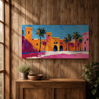 Panoramic painting of a Moroccan kasbah with tall palm trees and arched fortress gates rendered in bold palette knife brushstrokes. Bright orange, pink, and terracotta buildings contrast against a vivid blue sky, capturing the architecture of a Marrakech medina with textured walls and sunlit desert tones.
