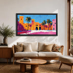 Panoramic painting of a Moroccan kasbah with tall palm trees and arched fortress gates rendered in bold palette knife brushstrokes. Bright orange, pink, and terracotta buildings contrast against a vivid blue sky, capturing the architecture of a Marrakech medina with textured walls and sunlit desert tones.