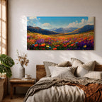Panoramic painting of a vibrant mountain meadow filled with colorful wildflowers stretching toward distant alpine peaks. Red, yellow, purple, and blue blossoms cover the valley floor beneath a bright sky with soft clouds, while layered mountains rise along the horizon in a luminous natural landscape.