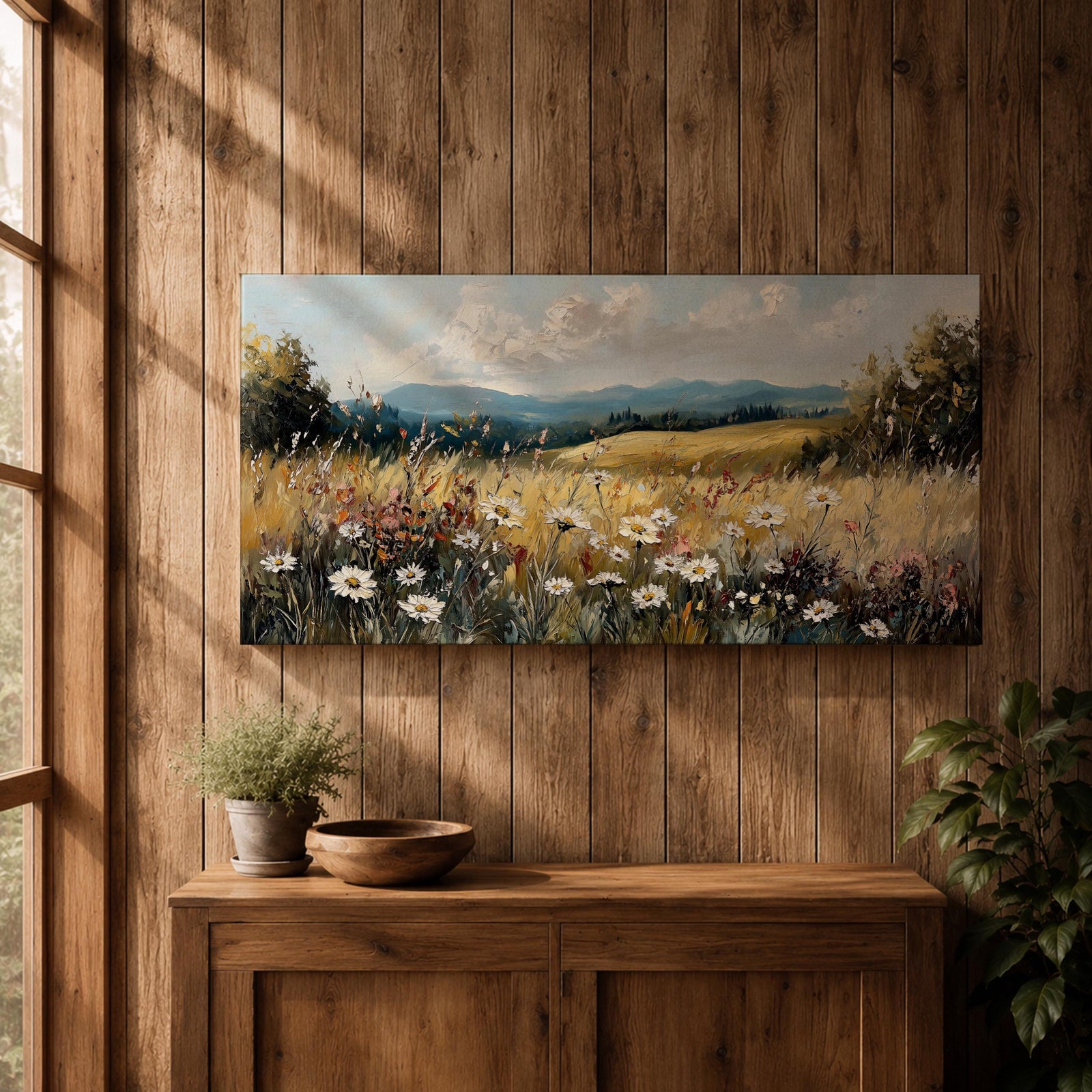 Panoramic painting of a peaceful wildflower meadow filled with blooming daisies and tall grasses across rolling countryside fields. Soft clouds stretch above distant hills while warm golden tones and textured brushstrokes create a calm rural landscape scene.