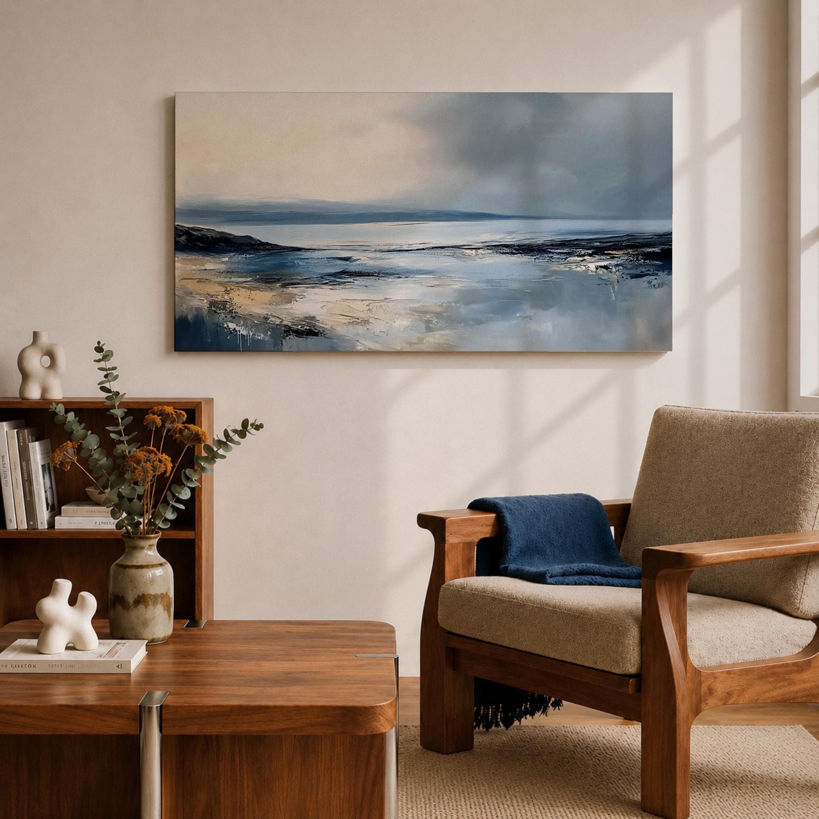 Panoramic abstract coastal seascape painting featuring a calm ocean shoreline with soft blue, gray, and sandy tones reflecting across the water beneath a cloudy horizon.