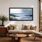 Panoramic abstract coastal seascape painting featuring a calm ocean shoreline with soft blue, gray, and sandy tones reflecting across the water beneath a cloudy horizon.
