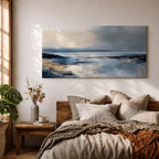 Panoramic abstract coastal seascape painting featuring a calm ocean shoreline with soft blue, gray, and sandy tones reflecting across the water beneath a cloudy horizon.