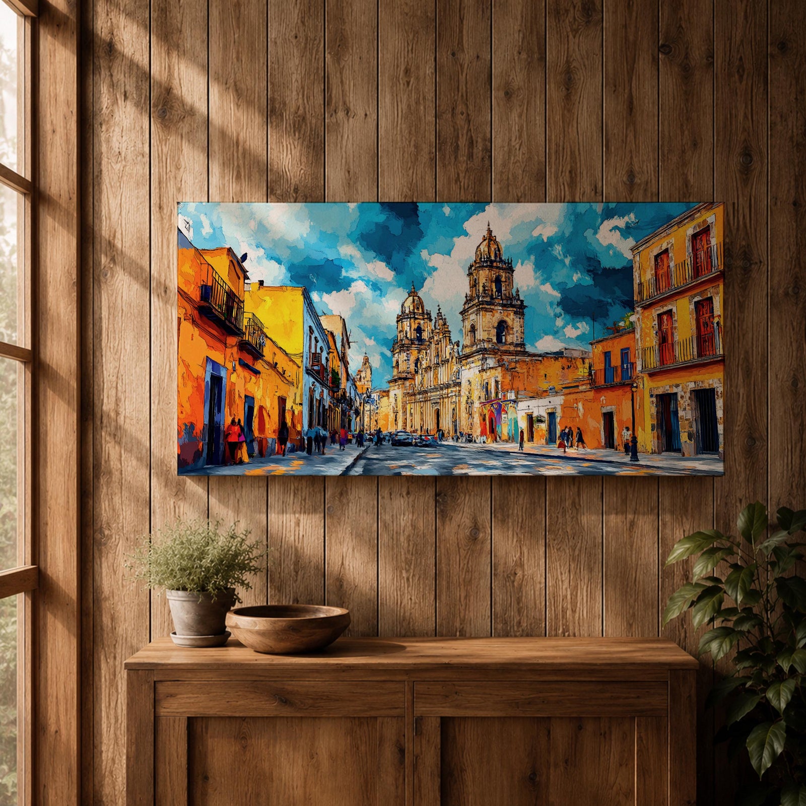 Panoramic painting of Oaxaca cathedral rising above a colorful colonial street lined with bright orange and yellow buildings. The historic Mexican architecture features twin cathedral towers beneath a dramatic blue sky with expressive painterly brushstrokes.