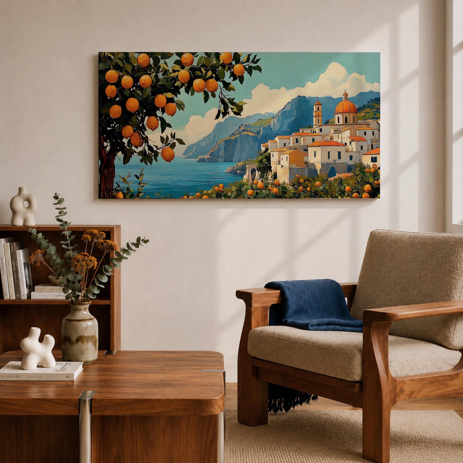 Panoramic coastal artwork showing a Mediterranean village overlooking the sea with white buildings and a domed church set against blue mountains. In the foreground a large lemon tree heavy with bright citrus fruit frames the scene while additional lemons and greenery fill the lower landscape, creating a vibrant Amalfi Coast inspired composition.