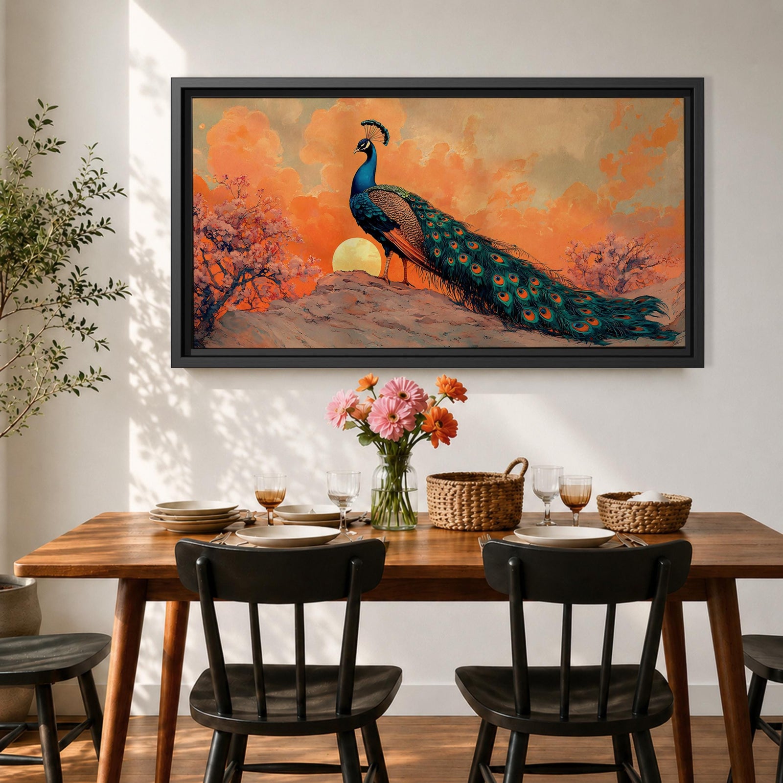 Panoramic artwork depicting a peacock standing on a rocky hill with its long iridescent tail feathers flowing behind it. The bird faces a glowing sunset with warm orange clouds and soft light illuminating the detailed blue and green plumage while flowering trees frame the scene.