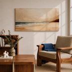 Panoramic coastal landscape painting showing a quiet sandy beach with gentle ocean waves rolling onto the shore beneath a soft sky. Subtle tones of beige, blue, and warm gray create a calm atmosphere while distant hills stretch along the horizon and light reflects across the water.