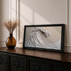 Panoramic textured relief artwork depicting a powerful ocean wave curling upward in sculpted layered forms. The cresting breaker is rendered with thick plaster like ridges and flowing contours in soft neutral tones, creating a minimalist seascape with depth and movement across the wide horizontal composition.