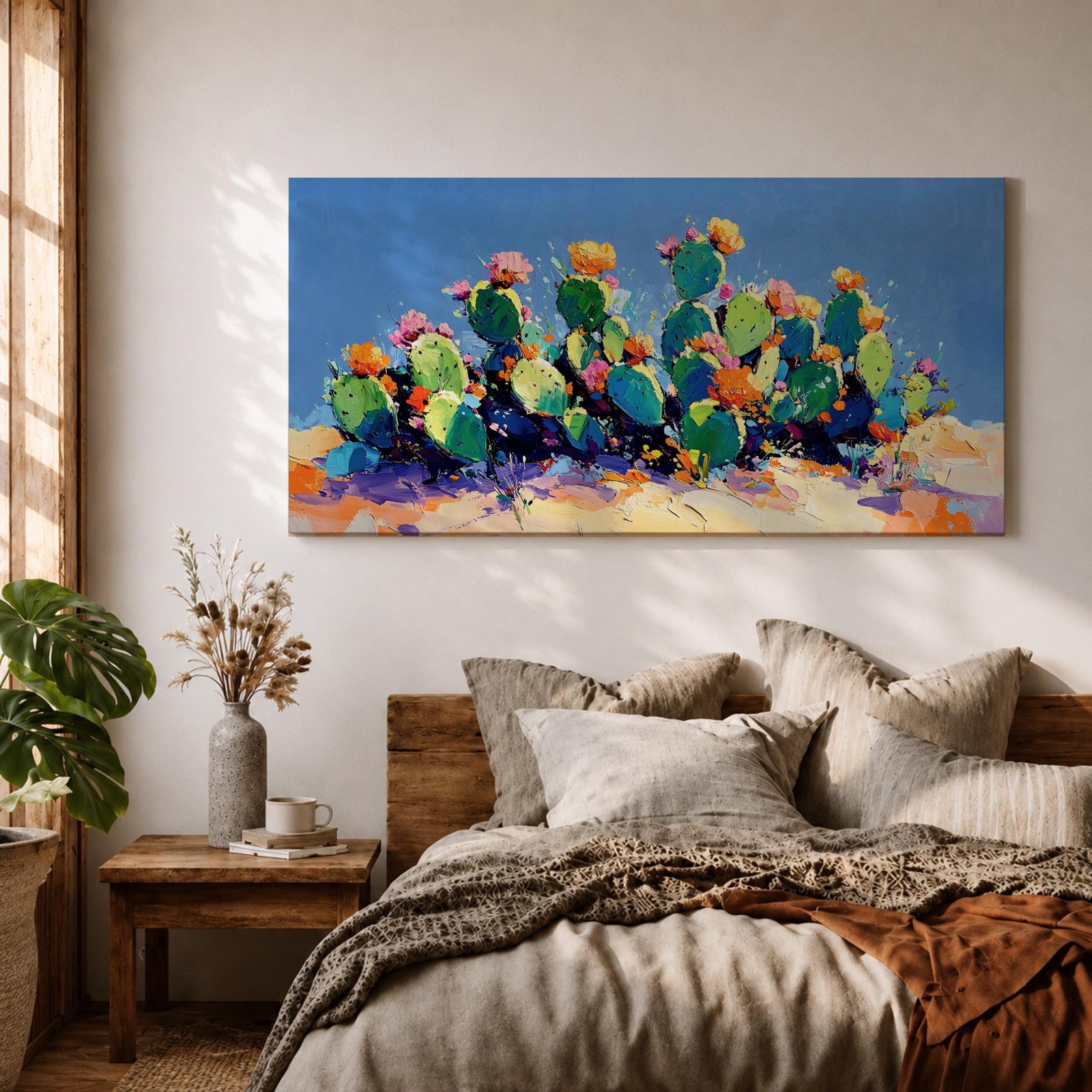 Panoramic painting of desert prickly pear cactus plants with bright pink and yellow blooming flowers growing across a colorful arid landscape. Thick palette knife brushstrokes create textured cactus pads vibrant blossoms and layered desert hills beneath a glowing sky forming a wide southwestern desert scene.