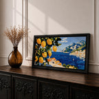 Panoramic painting of bright yellow lemons hanging from leafy branches overlooking the Amalfi Coast with deep blue Mediterranean water, sailboats, and a hillside Italian village with terracotta roofs beneath rugged mountains. Thick palette knife brushstrokes create textured citrus fruit foliage and coastal architecture in a wide landscape composition.
