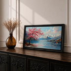 Panoramic painting of a cherry blossom tree in full bloom beside a calm mountain lake with snow covered peaks in the distance and soft clouds above. Pink petals drift across the water while thick palette knife brushstrokes create texture in the blossoms shoreline and reflections forming a wide spring landscape scene with bold color contrast.