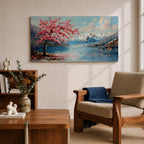 Panoramic painting of a cherry blossom tree in full bloom beside a calm mountain lake with snow covered peaks in the distance and soft clouds above. Pink petals drift across the water while thick palette knife brushstrokes create texture in the blossoms shoreline and reflections forming a wide spring landscape scene with bold color contrast.