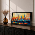Panoramic abstract painting of Al Masjid an Nabawi in Medina featuring the mosque domes and tall minarets with the iconic green dome at the center. The architecture is rendered with geometric block brushstrokes in vibrant blues, reds, yellows and oranges creating a modern cityscape style composition.