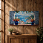 A panoramic painting of a Mediterranean seaside village viewed through a stone arch window, featuring blue ocean waters, sailboats, terracotta rooftops, and vibrant floral pots.