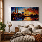 A vibrant panoramic painting of an Islamic city skyline with domes and minarets at sunset, reflecting in water below, rendered in bold expressive brushstrokes with rich orange, blue, and gold tones.