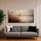 Panoramic landscape painting of soft pink wildflowers and tall grasses growing along a calm lakeshore. The scene features delicate meadow blooms in the foreground with textured brushstrokes and warm earthy tones, fading into a misty reflective lake and distant horizon under a gentle sky.